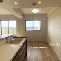 バルコニー側の小窓から光が差し込む明るいキッチン。