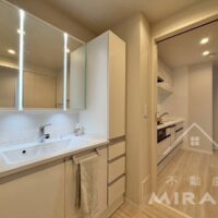 新しく交換された収納充実の洗面台。キッチン・洗面台・浴室と水廻りがつながる大変便利な動線になっています。